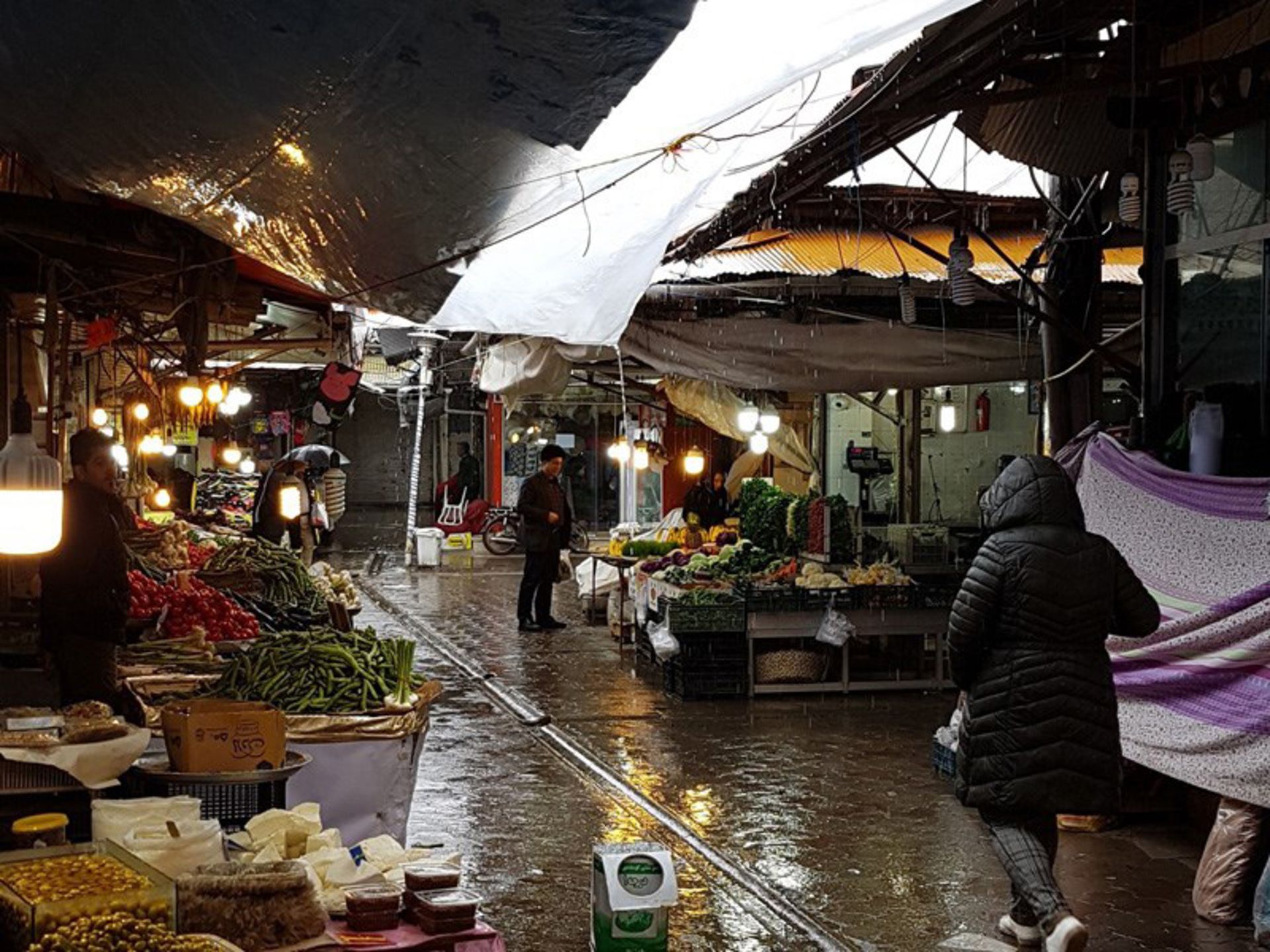 Fruits, fresh vegetables, pickled garlic in the traditional market of Lahijan in rainy weather