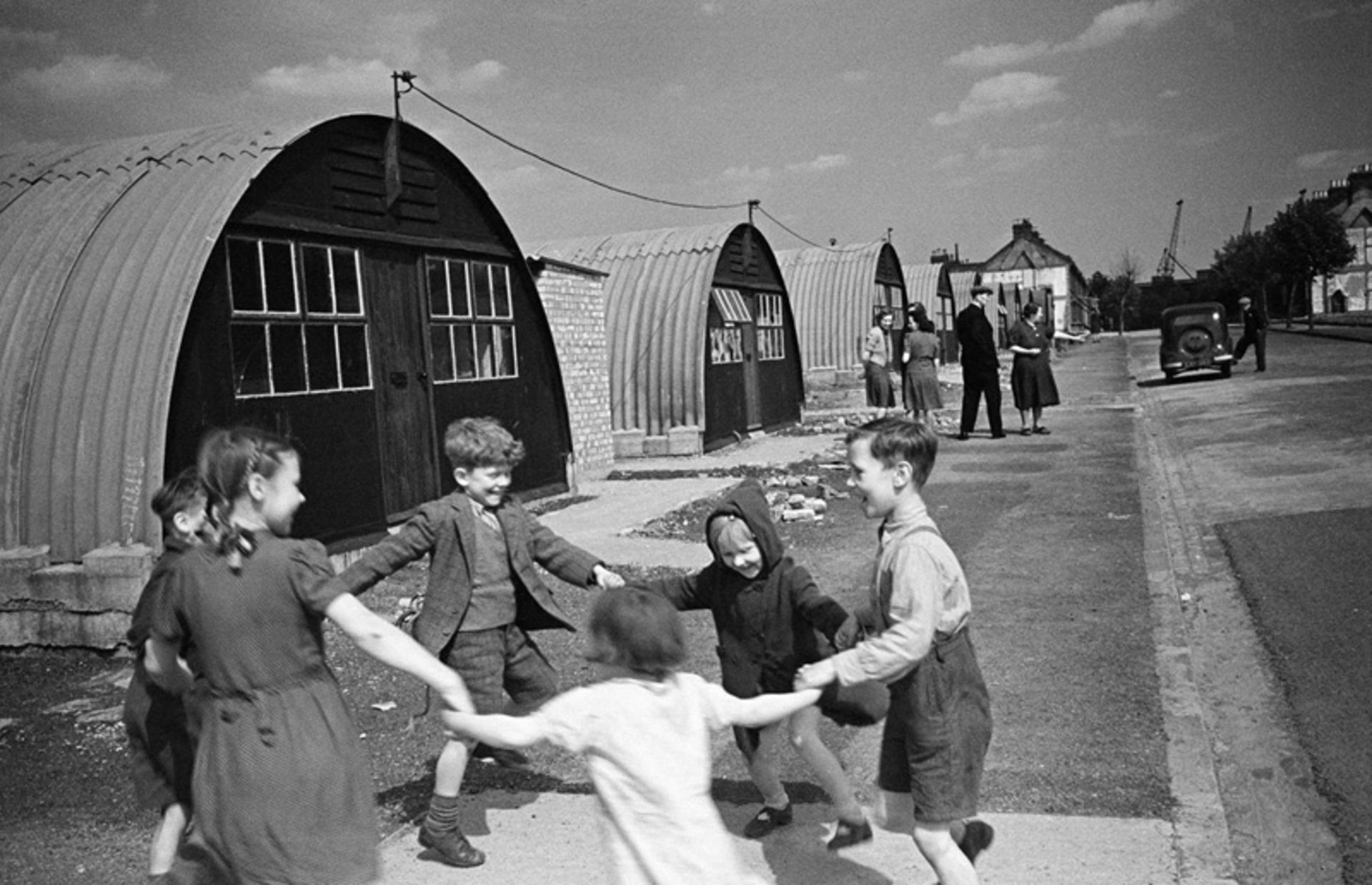Children play next to one-story prefabricated houses