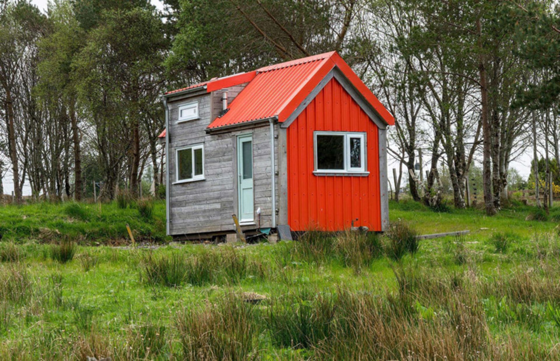 Small and minimal red house in nature