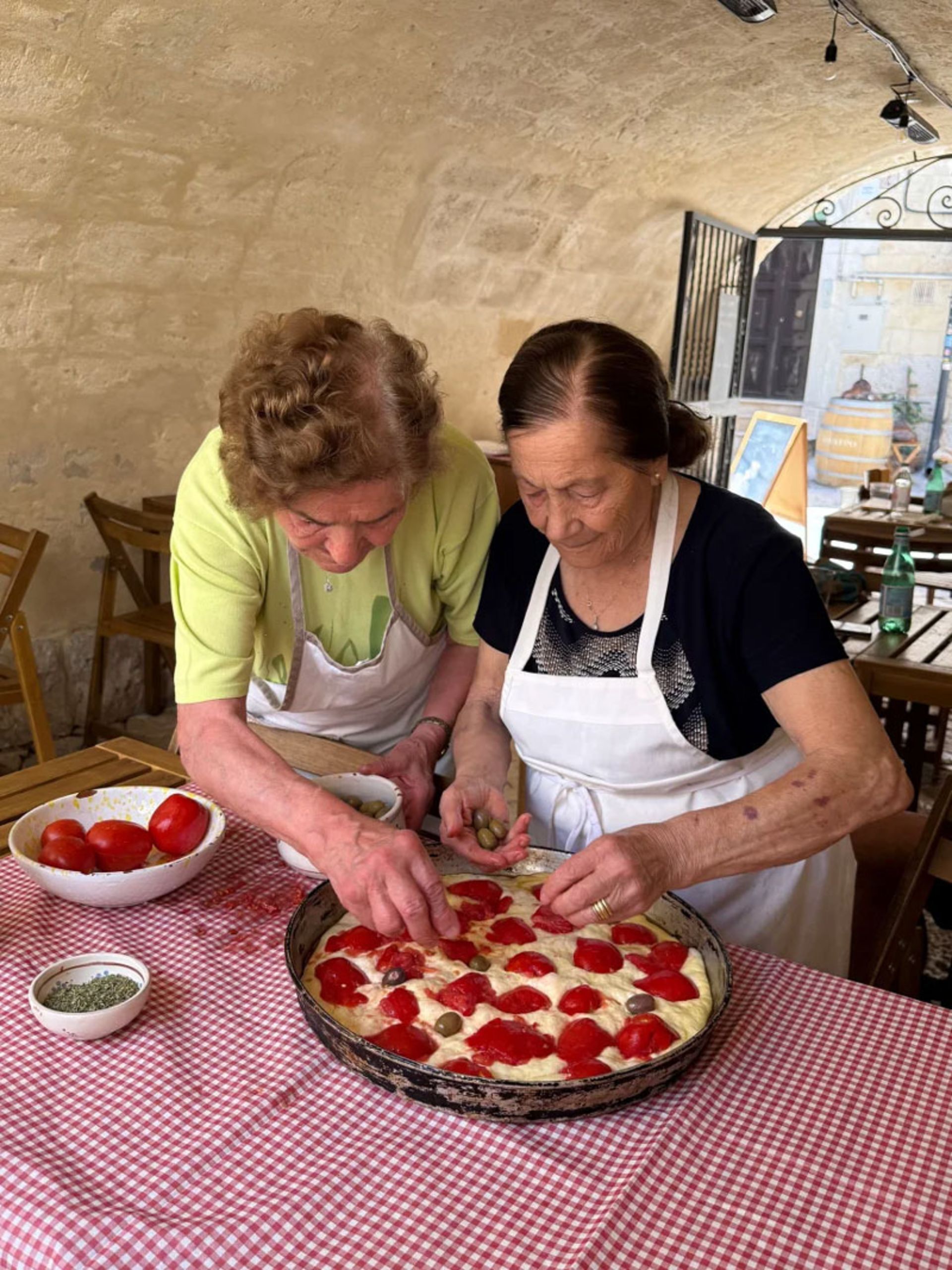Two Italian grandmothers preparing pizza