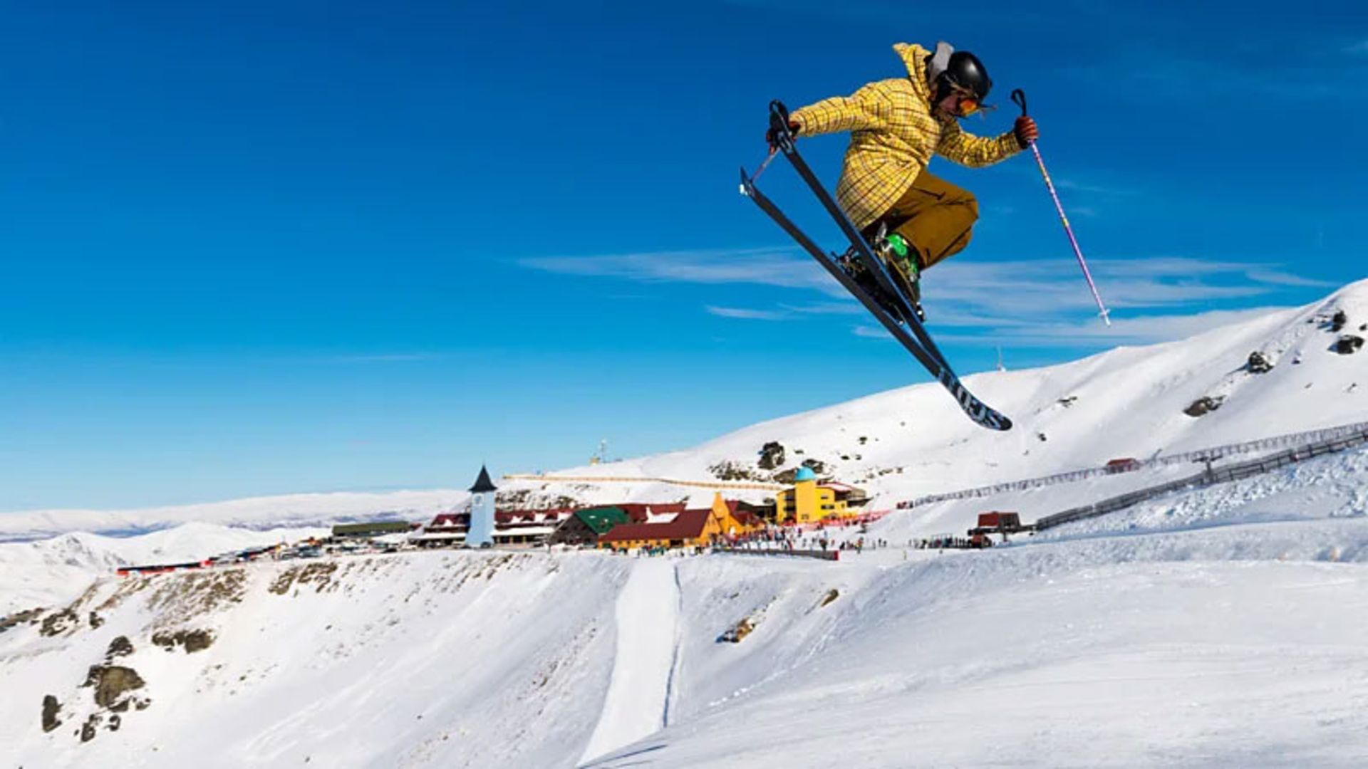 Spectacular and exciting jump of a skier in the blue sky