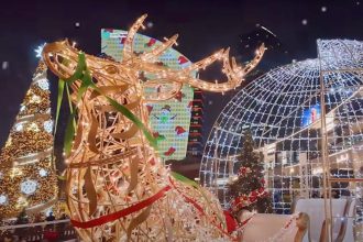 A picture of a Christmas night market with a reindeer statue in Dubai