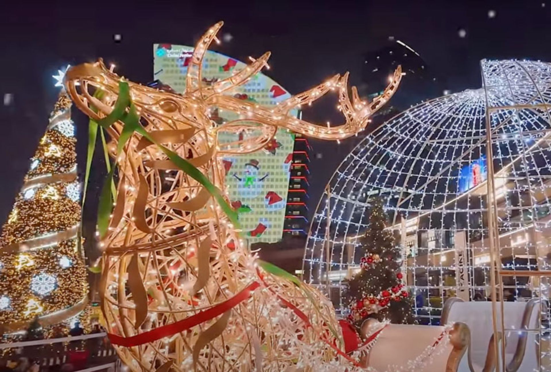 A picture of a Christmas night market with a reindeer statue in Dubai