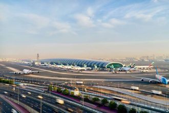 Aerial view of the runway and terminal of Dubai International Airport during the day