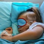 Baby sleeping with airplane pillow and blanket