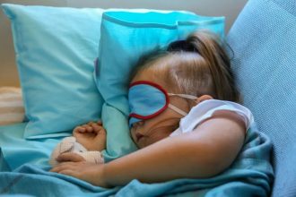 Baby sleeping with airplane pillow and blanket