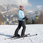 A skier ready to go with a magnificent backdrop of the mountains of the Dolomite region