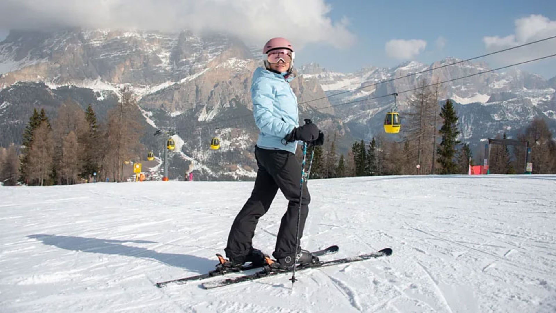 A skier ready to go with a magnificent backdrop of the mountains of the Dolomite region