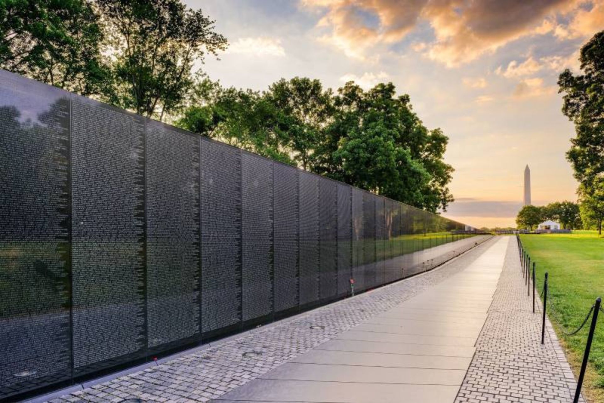 The black wall of the Vietnam Veterans Memorial and the surrounding greenery