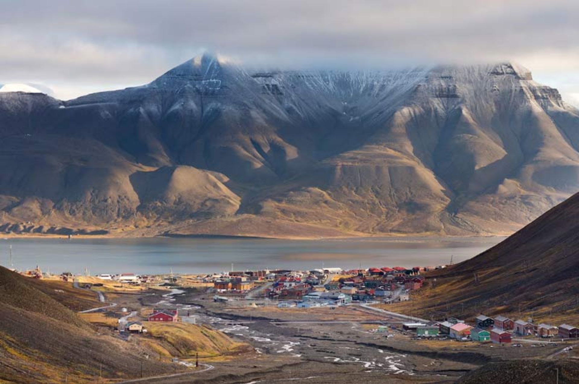 A distant view of the small town of Llangirbyn, nestled in a valley between huge, misty mountains
