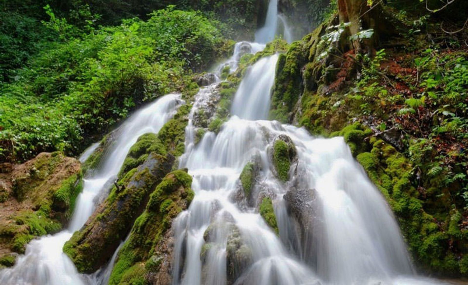 Oben Sari waterfall in the middle of green valleys
