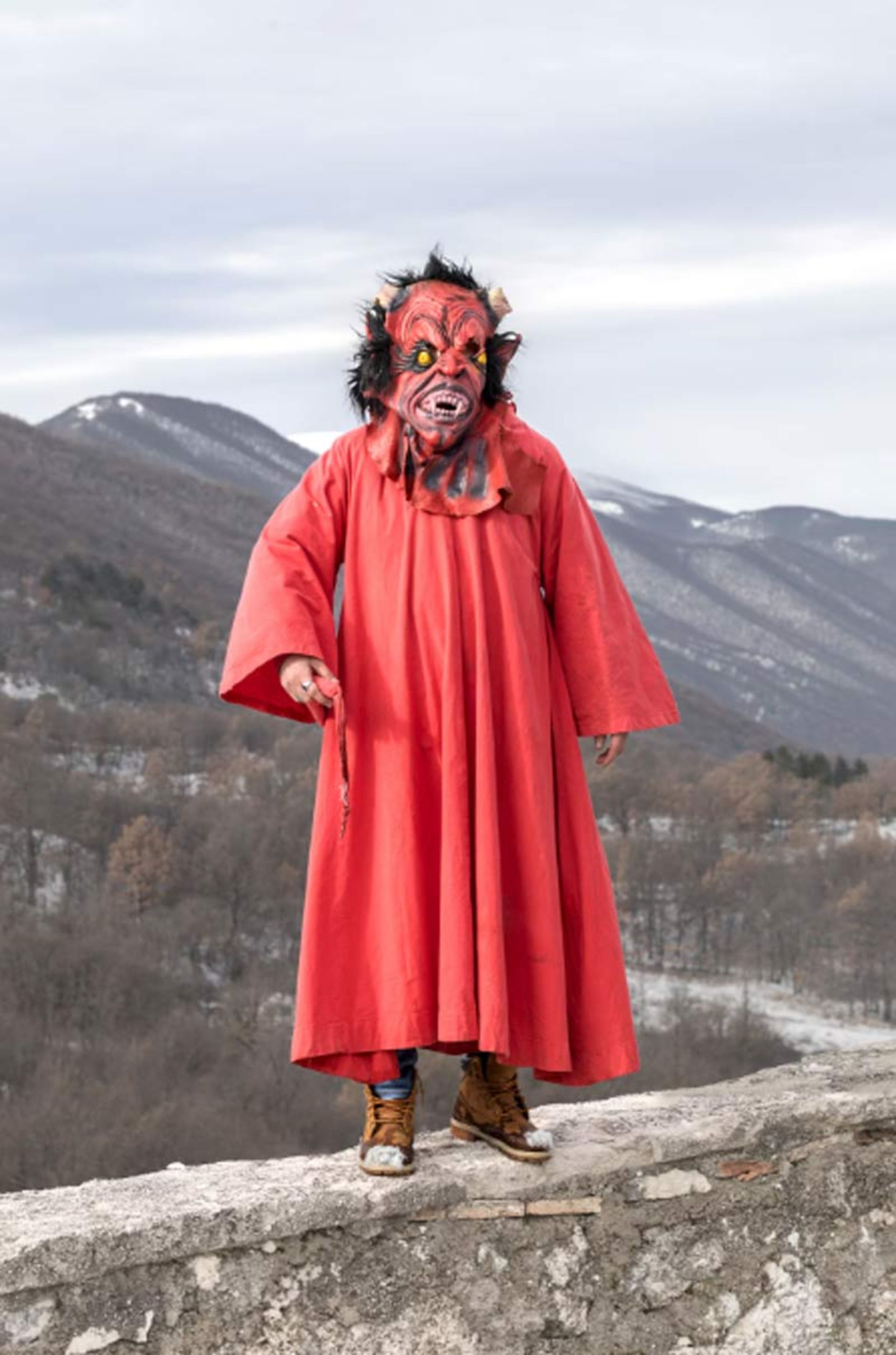 Participant of the Panarda festival wearing a mask with the face of the devil