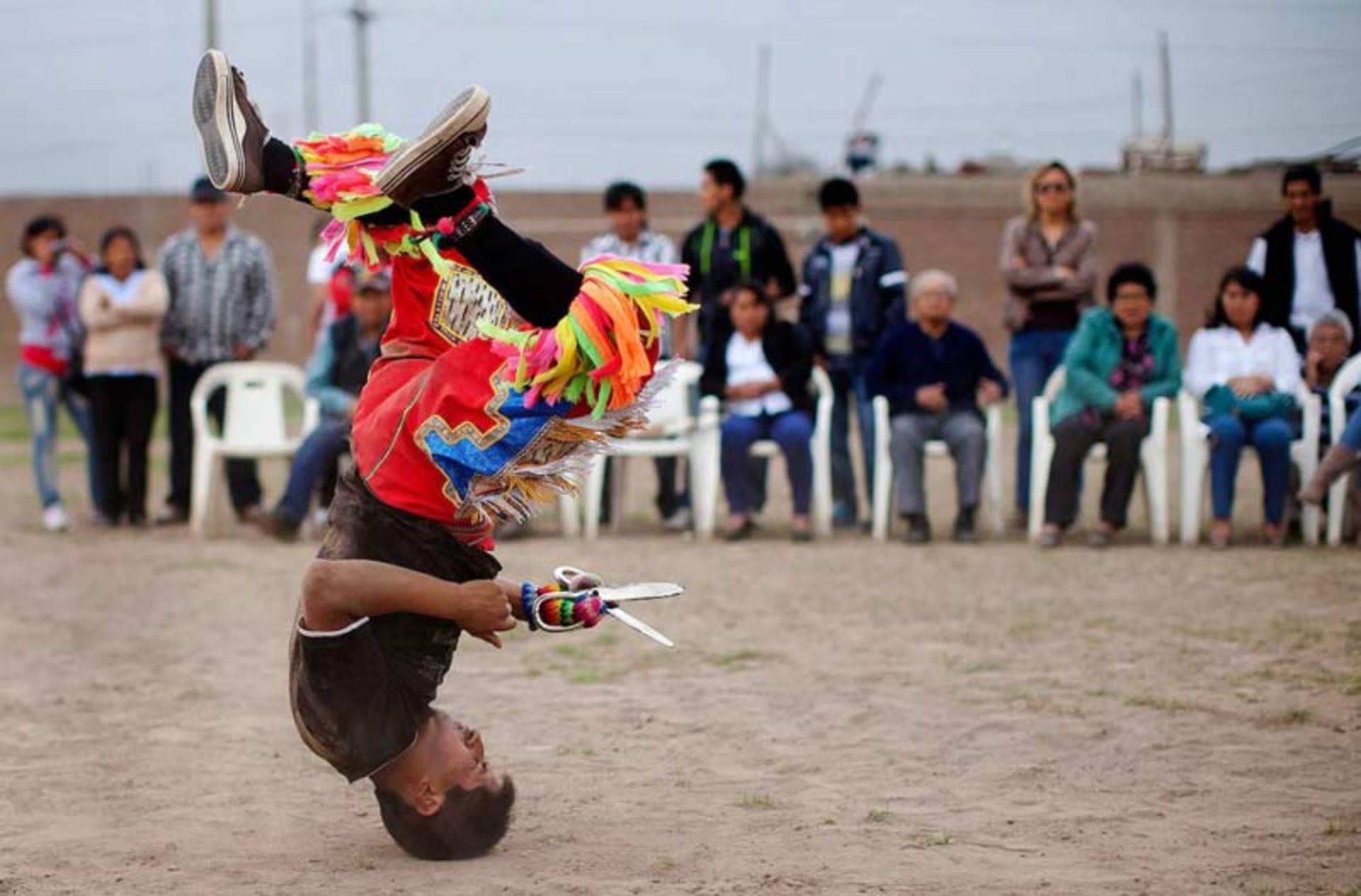 Scissors dancer performing an acrobatic overhead move