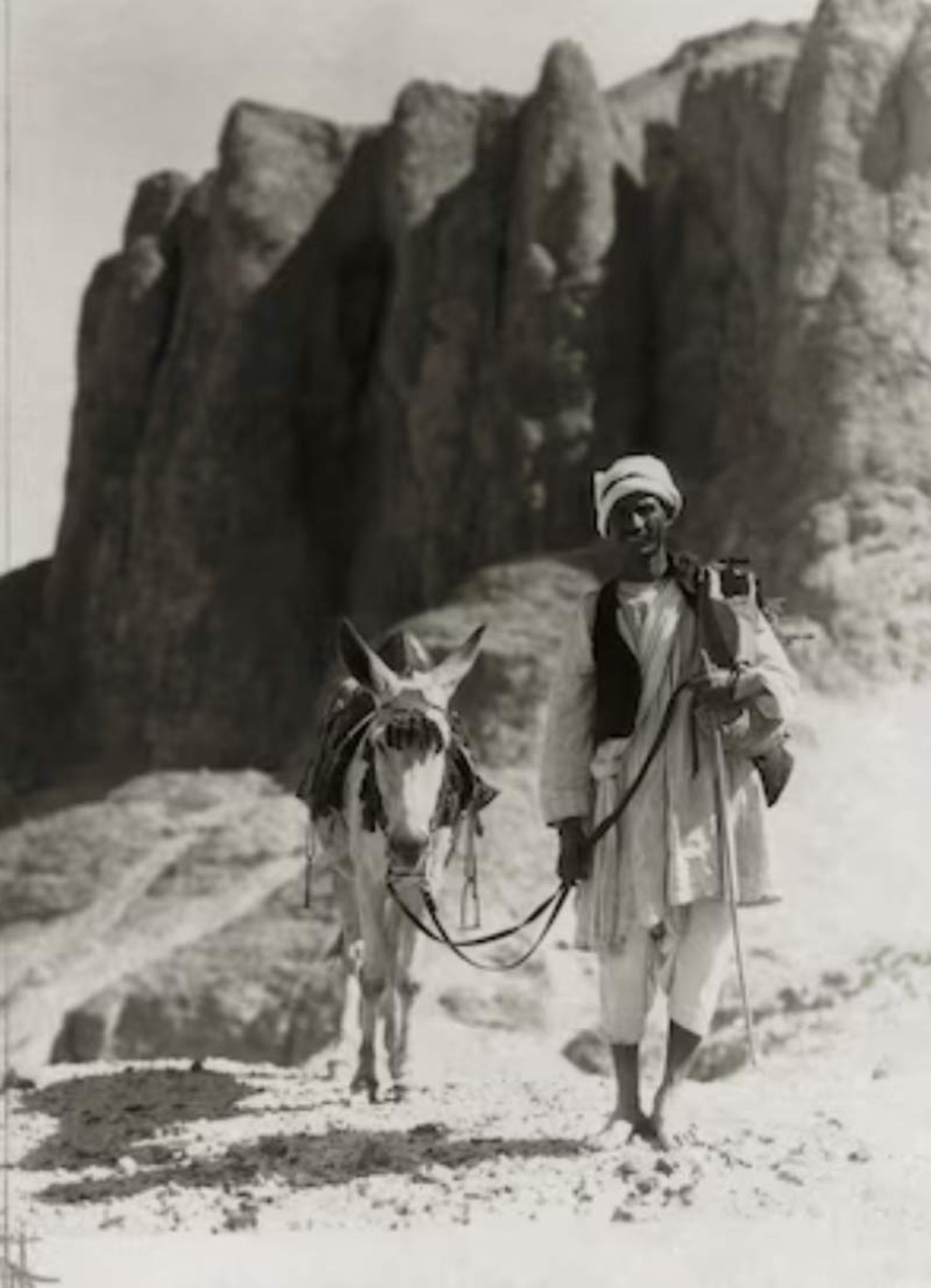 A local Egyptian man leading a donkey through the rocky and rough paths of the Valley of the Kings