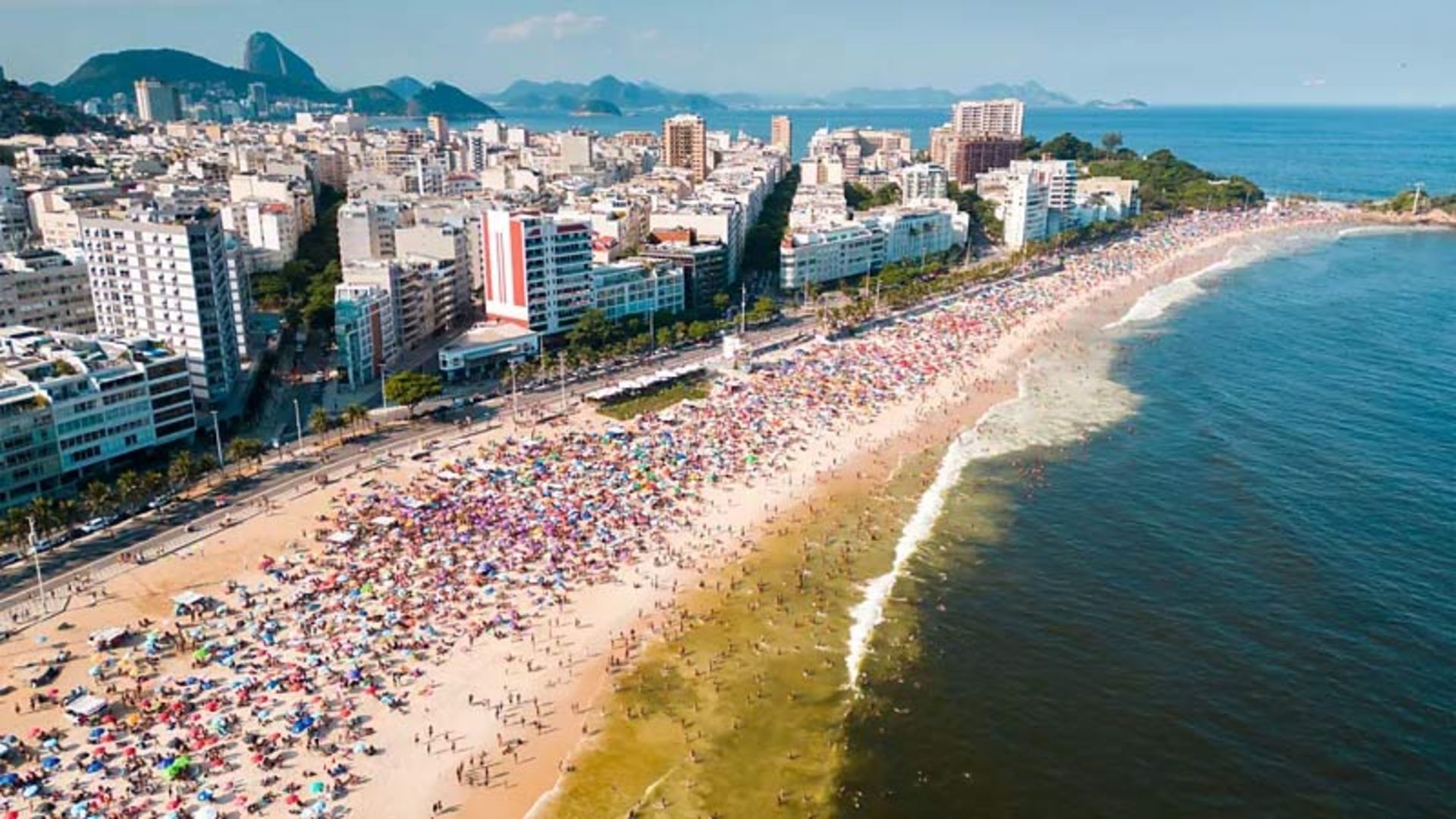 Aerial view of a very busy beach full of colorful umbrellas in the city of Rio de Janeiro