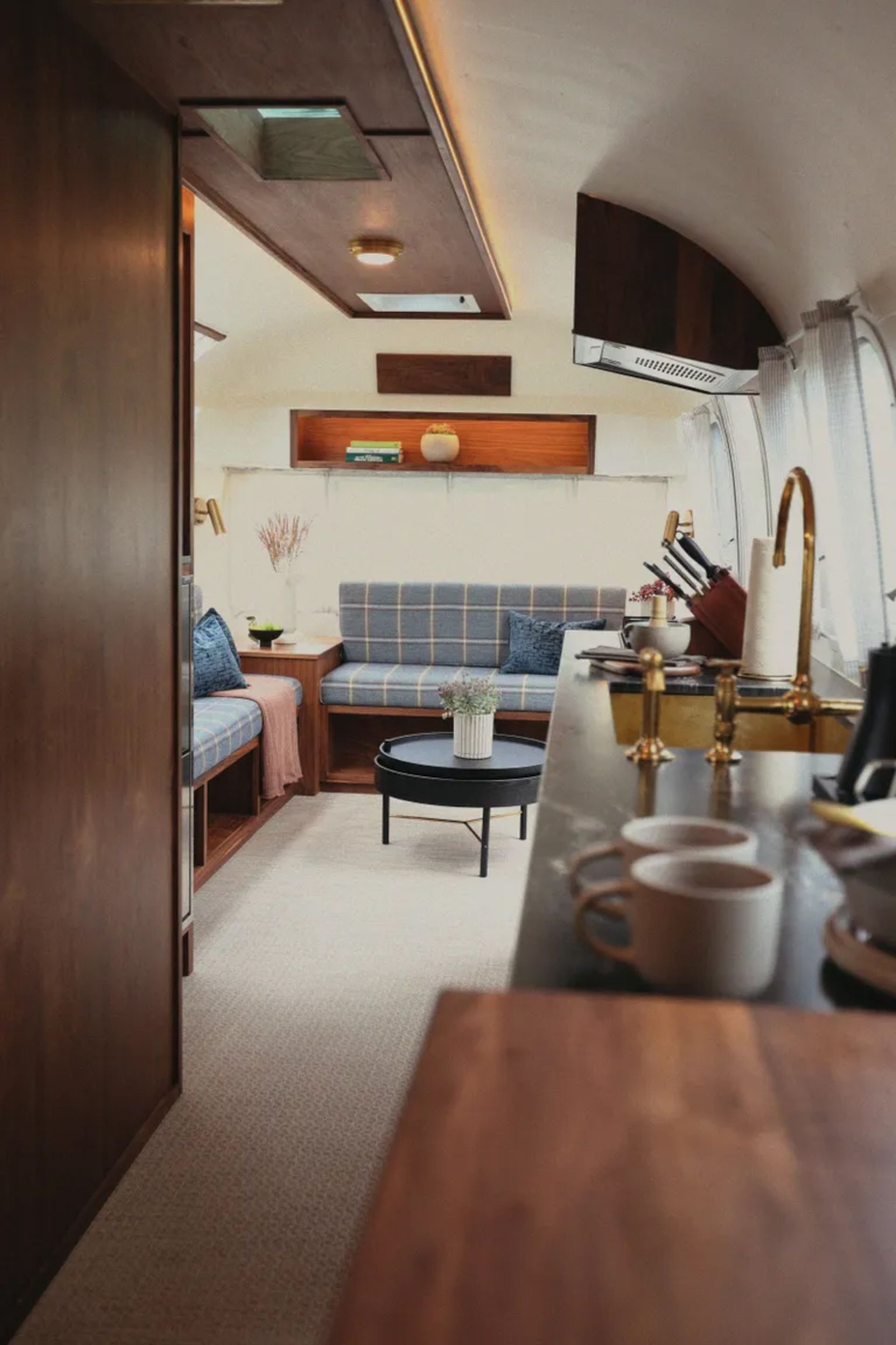 Modern and luxurious interior design of airstream caravan with wooden cabinets and brass faucets