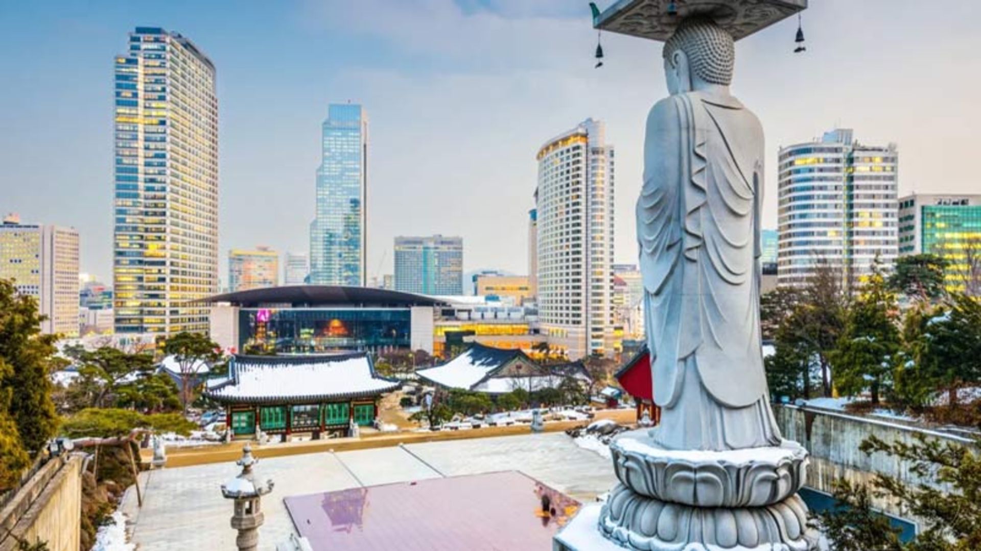 Big Buddha in front of the modern skyscrapers of Seoul