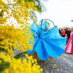A blue-dressed dancer performing at the Mimosa Yellow Flower Festival in the south of France
