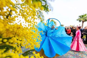 A blue-dressed dancer performing at the Mimosa Yellow Flower Festival in the south of France