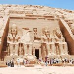 Entrance view of Abu Simbel Temple with giant statues of Ramses II and the presence of tourists